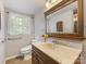 Traditional bathroom featuring a wood vanity, framed mirror, and window with natural light at 5114 Glenbrier Dr, Charlotte, NC 28212