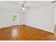 Spacious bedroom with hardwood floors, white walls, and a large window providing ample light at 5114 Glenbrier Dr, Charlotte, NC 28212