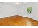Bright bedroom features wood floors, white walls, a ceiling fan, and a window at 5114 Glenbrier Dr, Charlotte, NC 28212