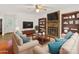 Inviting living room featuring a brick fireplace, built-in shelves, and comfortable seating area at 5114 Glenbrier Dr, Charlotte, NC 28212