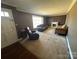 A living room features a large window, a brown sofa and dated carpeting at 5226 Indian Trail Fairview Rd, Indian Trail, NC 28079