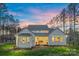 Back exterior view of home highlighting lawn, fenced yard, and windows providing ample natural light at 6398 Chimney Bluff Rd, Lancaster, SC 29720
