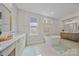 Elegant bathroom featuring a soaking tub, dual vanity, and natural light at 6398 Chimney Bluff Rd, Lancaster, SC 29720