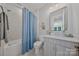Well-lit bathroom featuring a shower-tub combo with a blue patterned shower curtain and modern vanity at 6398 Chimney Bluff Rd, Lancaster, SC 29720