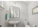Stylish powder room with a pedestal sink, decorative mirror, and modern fixtures, perfect for guests at 6398 Chimney Bluff Rd, Lancaster, SC 29720