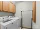Functional laundry room with side-by-side washer and dryer units and extra cabinet space at 7146 Sifford Rd, Stanley, NC 28164