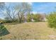 Expansive backyard with mature trees and open grassy area, ideal for recreation and gardening at 7207 Idlewild Rd, Charlotte, NC 28212