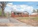 Cozy single-story brick home with a paved driveway, black shutters, and a classic gable roof at 7207 Idlewild Rd, Charlotte, NC 28212