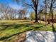 Large grassy backyard featuring mature trees and space for activities at 11712 Battery Pl, Charlotte, NC 28273