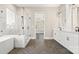 Bathroom featuring tub, glass enclosed shower, double vanity, and herringbone tile floors at 2017 Belle Grove Dr, Waxhaw, NC 28173