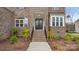 Charming brick home entrance with a beautiful doorway, brick stairs, and landscape at 2017 Belle Grove Dr, Waxhaw, NC 28173