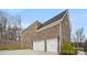 Two-car garage of a brick house with white doors and green space behind at 2017 Belle Grove Dr, Waxhaw, NC 28173