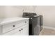 Laundry area features modern washer and dryer units with a white cabinet at 2017 Belle Grove Dr, Waxhaw, NC 28173