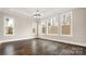 Spacious living room featuring dark wood floors, large windows, and modern chandelier at 2017 Belle Grove Dr, Waxhaw, NC 28173