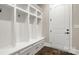 Bright mudroom with custom built-ins, bench, storage, and dark wood floors at 2017 Belle Grove Dr, Waxhaw, NC 28173