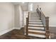 Elegant staircase with white risers, wood treads, and decorative iron railing at 2017 Belle Grove Dr, Waxhaw, NC 28173