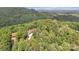 An aerial view of a beautiful home surrounded by lush green trees and rolling hills in the distance at 298 Poplar Grove Ct, Taylorsville, NC 28681