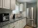 Well-lit kitchen with stainless steel fridge, granite countertops, and white cabinets, offering style and functionality at 3738 Ashley Hall Dr, Charlotte, NC 28227