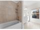 Bright bathroom featuring a tile shower/tub, dual vanity, and a window providing natural light at 415 Spring St, Davidson, NC 28036