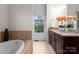Elegant bathroom featuring double sinks, granite countertops, and a soaking tub with tile surround at 415 Spring St, Davidson, NC 28036