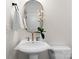 A crisp white bathroom with gold fixtures, accented by a decorative mirror and modern light fixtures at 415 Spring St, Davidson, NC 28036