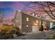 Brick townhome features an attached garage, dormer windows, and a landscaped yard against a dusk sky at 415 Spring St, Davidson, NC 28036