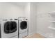 Functional laundry room featuring front-loading washer and dryer units and shelving for storage at 415 Spring St, Davidson, NC 28036