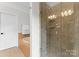 Modern tile shower with glass doors, rainfall showerhead, and built-in shelves in an elegant bathroom at 415 Spring St, Davidson, NC 28036