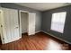 Bedroom featuring closet with double doors, wood-look flooring and neutral paint at 4825 Banfshire Rd # 28, Charlotte, NC 28215