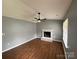 Open living room featuring new floors, a ceiling fan, and a brick fireplace at 4825 Banfshire Rd # 28, Charlotte, NC 28215