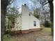 Home exterior featuring neutral siding, a brick foundation, and a chimney at 4825 Banfshire Rd # 28, Charlotte, NC 28215