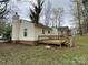 Back of house featuring a wooden deck with stairs, beige siding, and a chimney at 4825 Banfshire Rd # 28, Charlotte, NC 28215