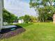 Large backyard with green grass, flower beds, and mature trees at 570 Key West Ave, Kannapolis, NC 28081