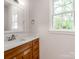 Bright bathroom with a wood vanity cabinet, framed mirror, and window providing natural light at 570 Key West Ave, Kannapolis, NC 28081
