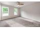 Sunlit bedroom with neutral walls, carpet, a ceiling fan, and windows at 570 Key West Ave, Kannapolis, NC 28081