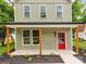 Inviting front porch featuring natural wood supports and a red door, framed by manicured landscaping at 570 Key West Ave, Kannapolis, NC 28081