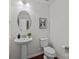 Well-lit powder room features a pedestal sink, wood flooring, and modern fixtures at 6004 Clover Hill Rd, Indian Trail, NC 28079