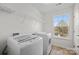 Well-lit laundry room with modern washer and dryer and shelving at 6004 Clover Hill Rd, Indian Trail, NC 28079