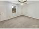 Comfortable carpeted bedroom with a ceiling fan and natural light from the window at 10707 Copper Field Dr, Pineville, NC 28134