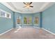 A spacious bedroom with large windows, a ceiling fan, and light blue walls at 11037 Thornbeck Ln, Midland, NC 28107