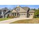 A close up showcases the attractive facade of this tan home with a large three-car garage at 11037 Thornbeck Ln, Midland, NC 28107