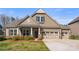 Charming home with a well-manicured lawn, stone accents, a covered front porch, and a three-car garage at 11037 Thornbeck Ln, Midland, NC 28107