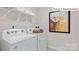 Clean laundry room with white washer and dryer, wire shelving, and modern art at 2048 Harlequin Dr, Indian Trail, NC 28079