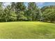 Expansive green lawn surrounded by mature trees, offering privacy and space for outdoor activities at 3004 Vernell Ln, Shelby, NC 28150