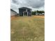 Home's backyard shows newly laid sod with partial grass coverage and trees in the distance at 309 Knotty Wood Dr # 78, Monroe, NC 28110