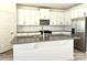 Bright kitchen featuring white cabinets, stainless steel appliances, a spacious island, and stylish backsplash at 313 Knotty Wood Dr # 79, Monroe, NC 28110