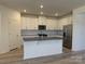 Modern kitchen features white cabinets, stainless steel appliances, and a center island, perfect for cooking at 313 Knotty Wood Dr # 79, Monroe, NC 28110