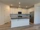 Modern kitchen features white cabinets, stainless steel appliances, and a center island, perfect for cooking at 313 Knotty Wood Dr # 79, Monroe, NC 28110