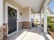 Inviting covered front porch with stone accents and decorative wreath on a dark-colored front door at 8137 Bryson Rd, Fort Mill, SC 29707