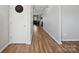 Well-lit hallway with hardwood flooring and neutral walls leads to various rooms in the home at 8137 Bryson Rd, Fort Mill, SC 29707